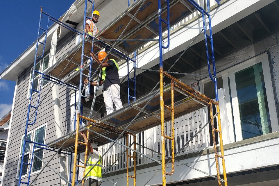 Restoration contractor applying a waterproof elastomeric coating to a building facade